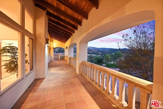 balcony at dusk featuring a mountain view