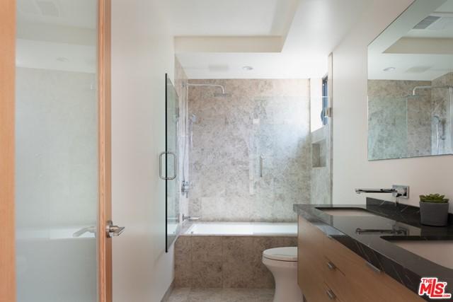 bathroom with double sink vanity, toilet, and tile floors