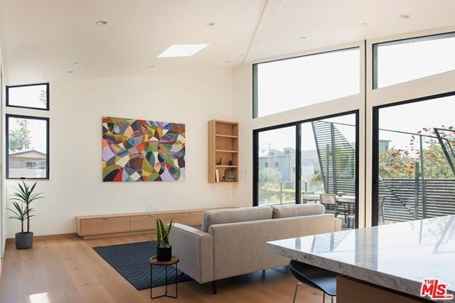 living room with a towering ceiling and light hardwood / wood-style flooring