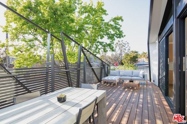 wooden terrace with an outdoor hangout area and a pergola