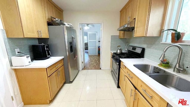 kitchen featuring ceiling fan, light tile floors, sink, appliances with stainless steel finishes, and tasteful backsplash