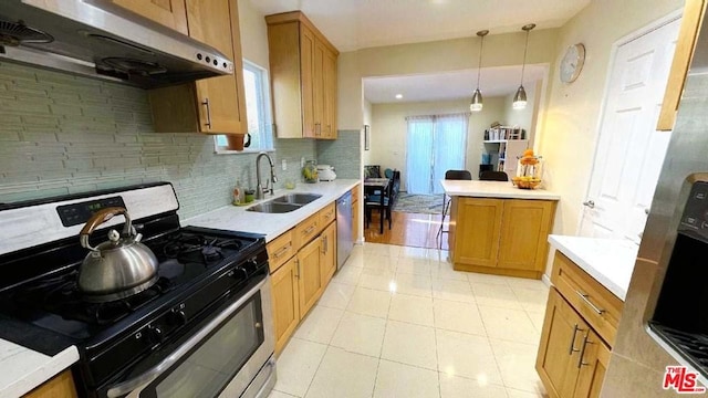 kitchen with tasteful backsplash, stainless steel appliances, light tile floors, decorative light fixtures, and sink