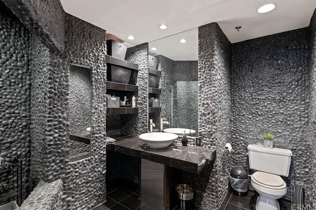 bathroom with tile patterned flooring, toilet, tile walls, and sink