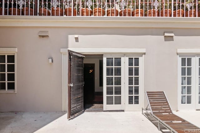 view of exterior entry featuring a patio area and french doors