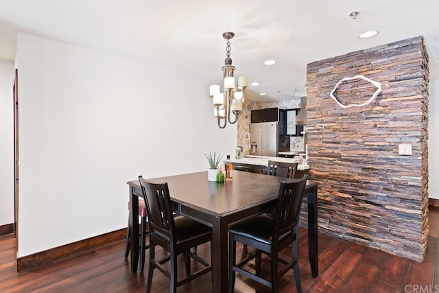 dining room featuring an inviting chandelier and dark wood-type flooring