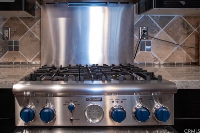 interior details with decorative backsplash and stainless steel gas cooktop