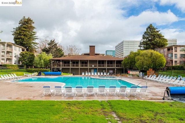 view of pool featuring a patio area and a lawn