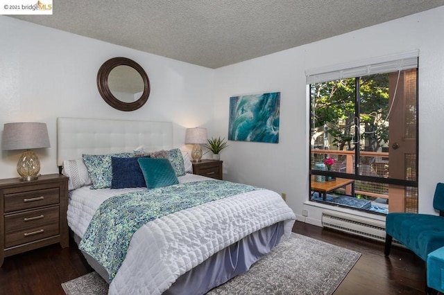 bedroom with a textured ceiling and dark hardwood / wood-style floors