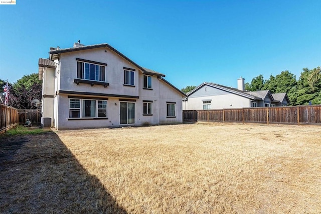 back of property featuring a yard and central AC unit