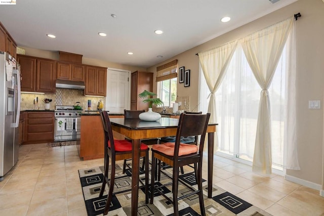 kitchen featuring light tile floors, appliances with stainless steel finishes, and backsplash