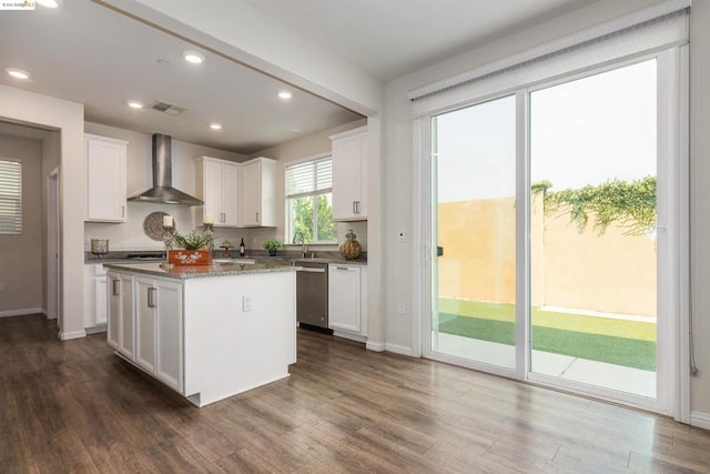 kitchen featuring wall chimney exhaust hood, white cabinetry, dark wood-type flooring, and stainless steel dishwasher