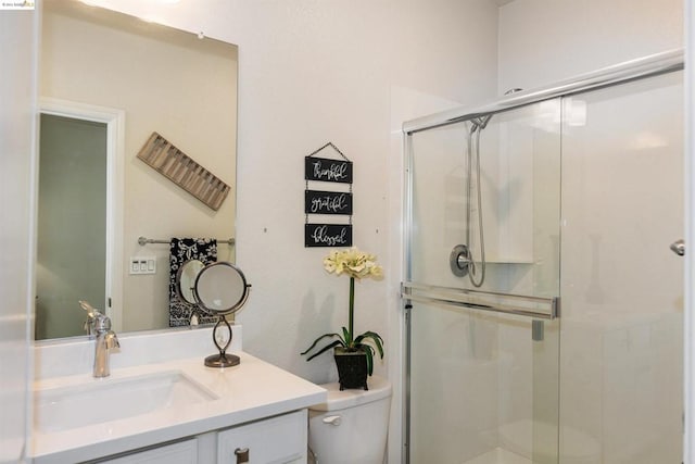 bathroom with toilet, an enclosed shower, and vanity