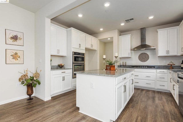 kitchen featuring light stone countertops, white cabinetry, dark wood-type flooring, and wall chimney range hood