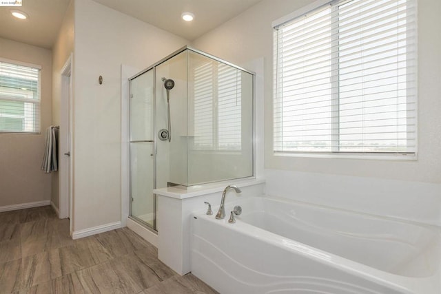 bathroom featuring plenty of natural light and independent shower and bath