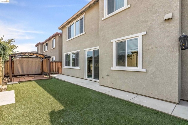 rear view of house with a lawn and a pergola