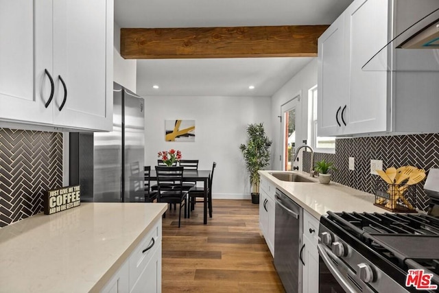 kitchen featuring white cabinets, appliances with stainless steel finishes, dark wood-type flooring, and sink