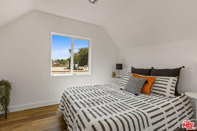 bedroom with lofted ceiling and dark hardwood / wood-style floors