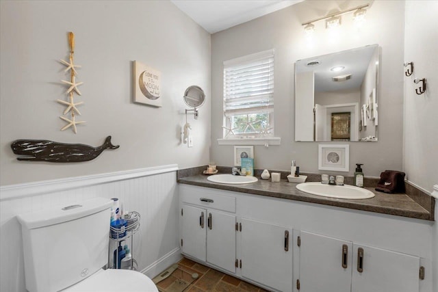 549 E Gulf Beach Dr, Saint George Islan, FL 32328 - bathroom with toilet, double vanity, and a wainscoted wall