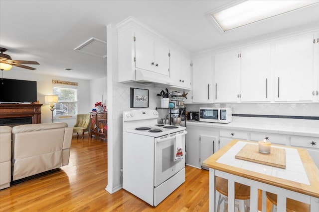 549 E Gulf Beach Dr, Saint George Islan, FL 32328 - kitchen featuring white appliances, open floor plan, white cabinetry, and light wood finished floors
