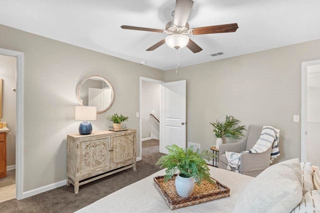 living area featuring ceiling fan and dark carpet