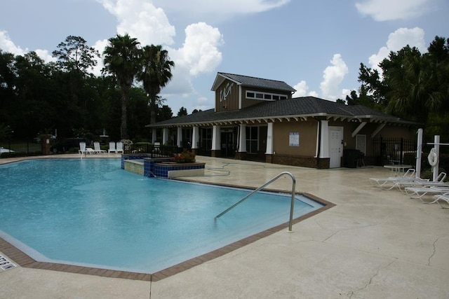 view of pool featuring pool water feature and a patio