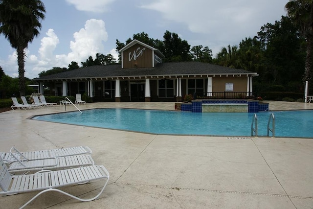 view of pool featuring pool water feature and a patio