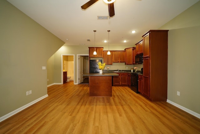 kitchen featuring black appliances, a kitchen island, light wood-type flooring, and pendant lighting