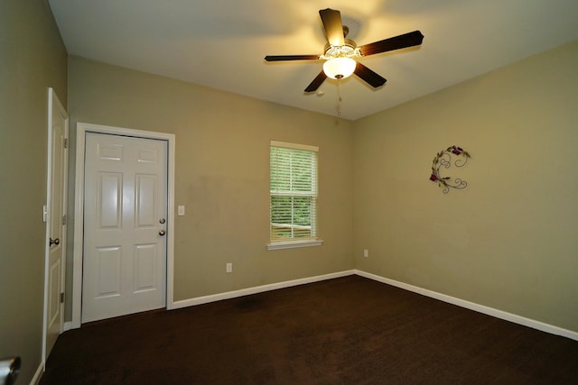 unfurnished room with ceiling fan and dark carpet