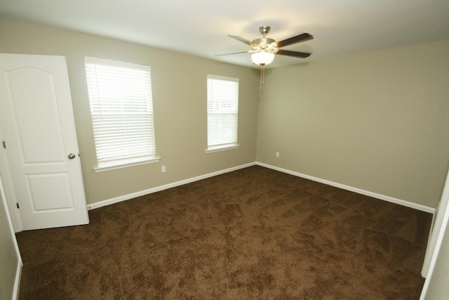 unfurnished room featuring dark carpet and ceiling fan