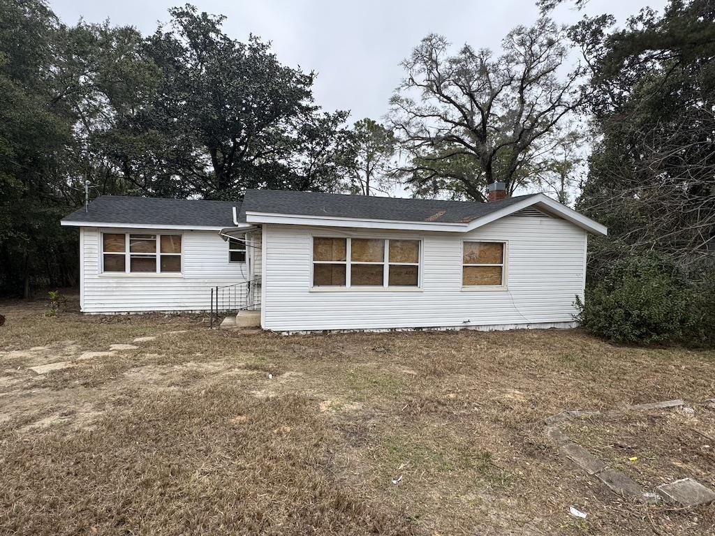 back of house featuring a lawn