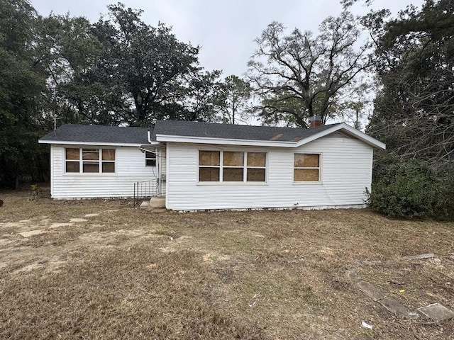 back of house featuring a lawn