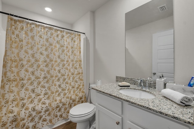 bathroom featuring toilet, vanity, and curtained shower