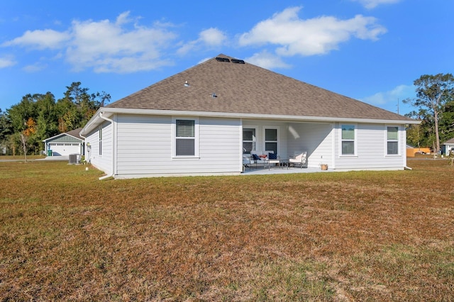 back of house with a garage, cooling unit, a lawn, and a patio