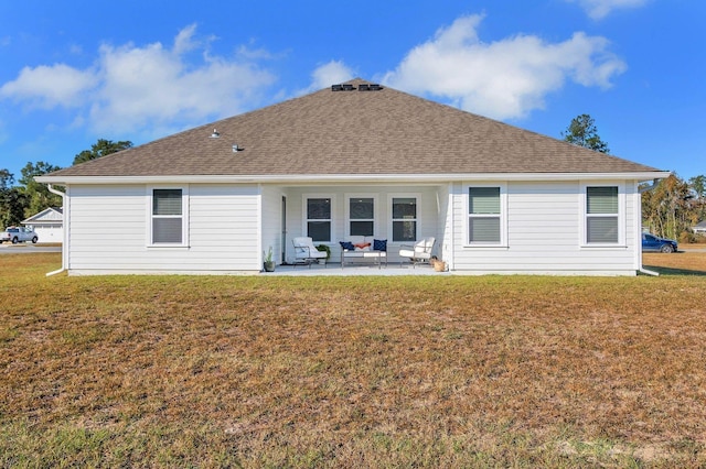 back of house with a lawn and a patio