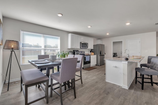 dining area with a wealth of natural light, wood-type flooring, and sink