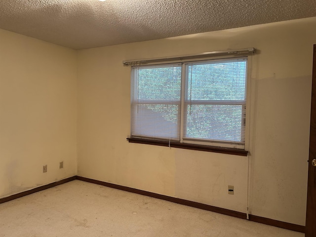 empty room featuring baseboards and a textured ceiling