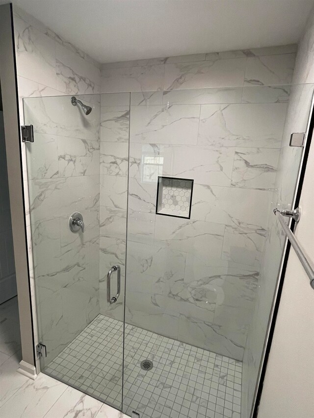 bathroom with a shower with door