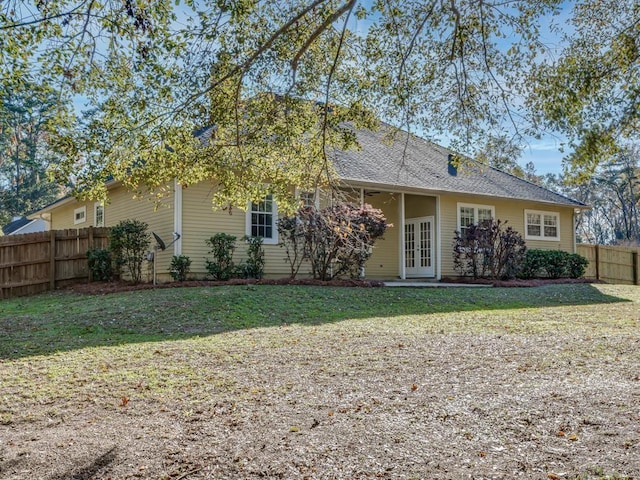 rear view of property featuring a lawn and french doors