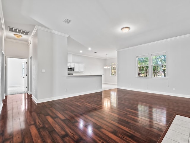 unfurnished living room with wood-type flooring, an inviting chandelier, and crown molding