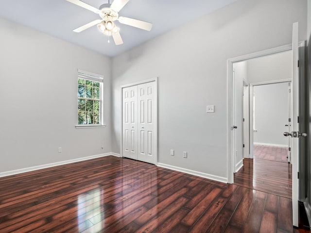 unfurnished bedroom with ceiling fan, a closet, and dark hardwood / wood-style floors