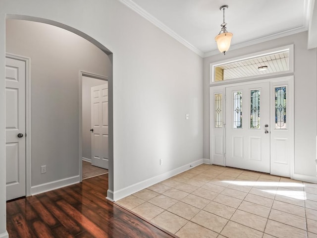 foyer with wood-type flooring and crown molding