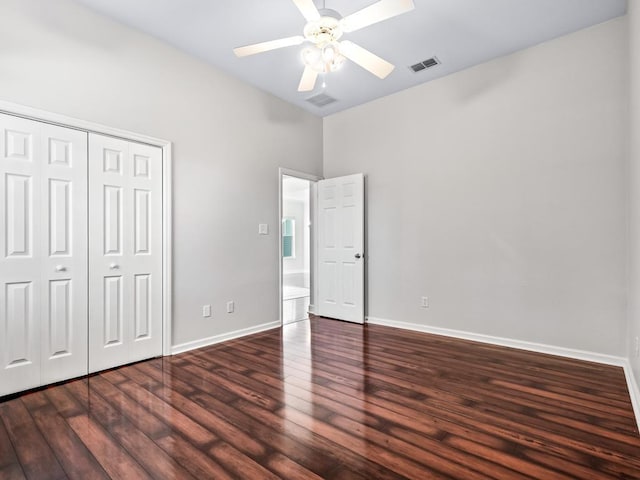 unfurnished bedroom with ceiling fan, dark hardwood / wood-style floors, and a closet