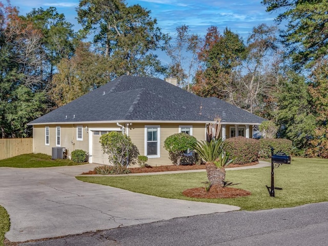 ranch-style home with central air condition unit, a front lawn, and a garage