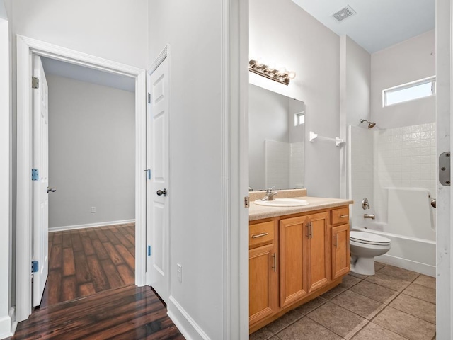 full bathroom featuring hardwood / wood-style floors, vanity, toilet, and shower / bathtub combination