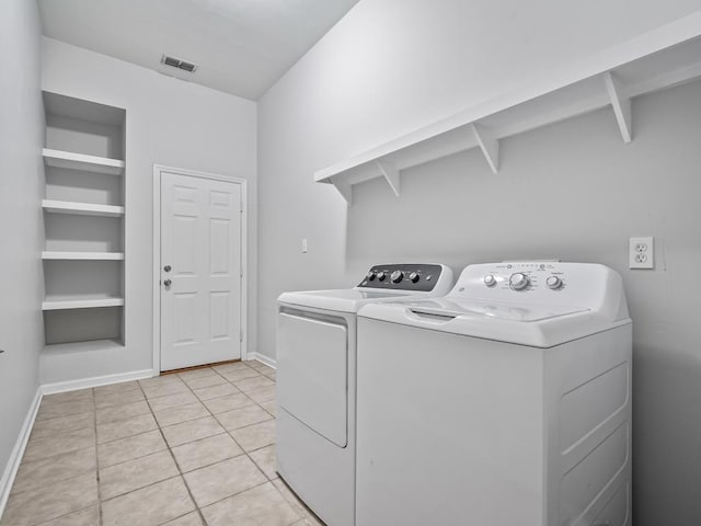 washroom featuring light tile patterned floors and washer and clothes dryer