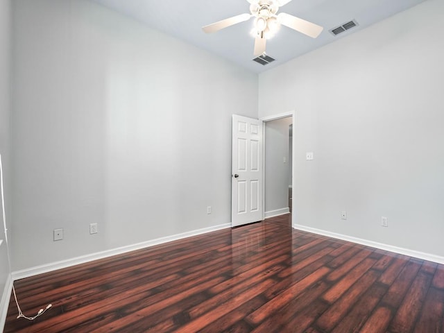 spare room with ceiling fan and dark wood-type flooring