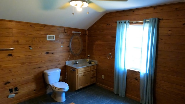 bathroom with vanity, wood walls, toilet, and lofted ceiling