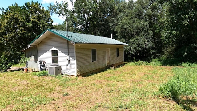 view of side of property featuring a lawn and central air condition unit