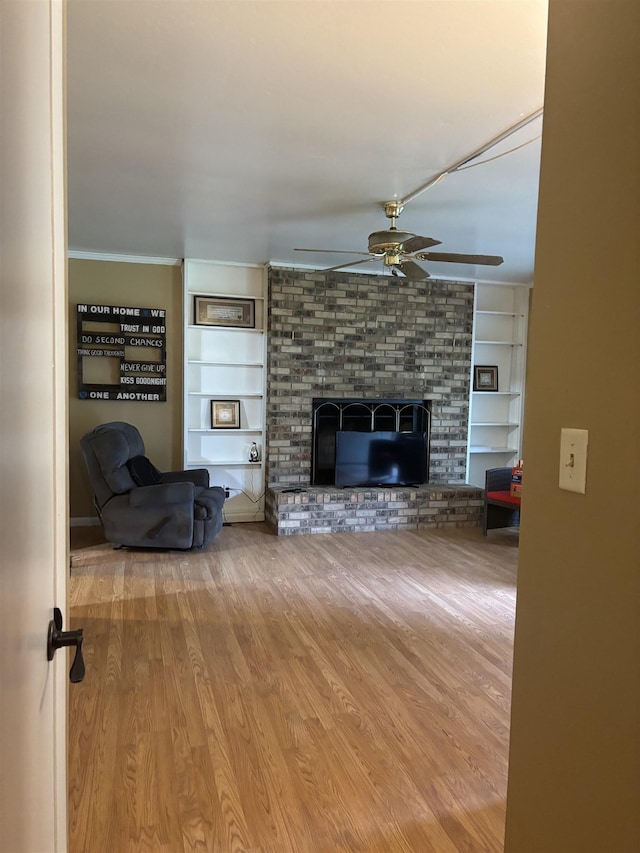 1208 Halifax Ct, Tallahassee, FL 32308 - living area featuring a ceiling fan, built in features, wood finished floors, a fireplace, and crown molding