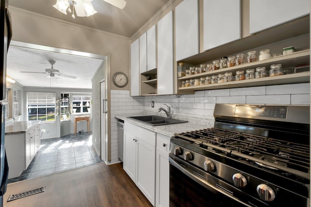 kitchen with white cabinetry, stainless steel appliances, dark wood-type flooring, light stone counters, and sink